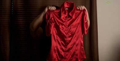 photo of a woman holding a red dress that obscures her face