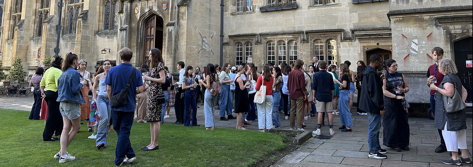 Students socializing on the front quod of Exeter College in front of the college's dining hall.