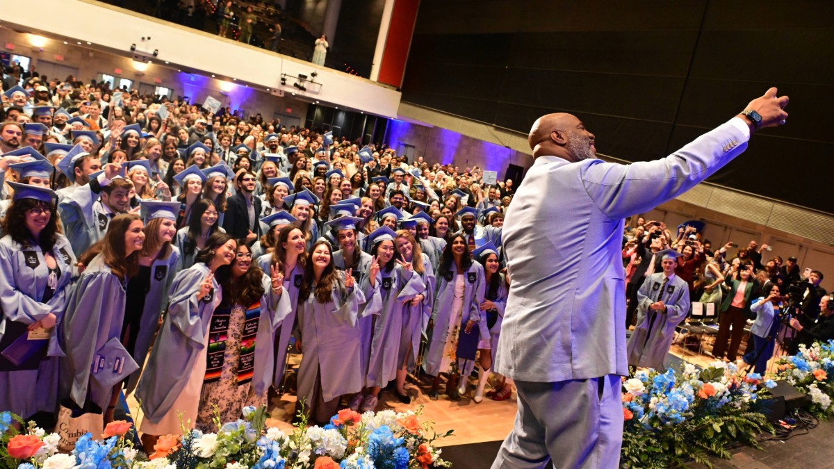 Man takes a selfie on a stage. 