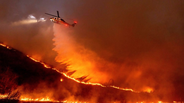 Water is dropped by helicopter on the Kenneth Fire in the West Hills section of Los Angeles. Photo by Ethan Swope/AP. Water is dropped by helicopter on the Kenneth Fire in the West Hills section of Los Angeles, on Thursday. (Ethan Swope/AP)