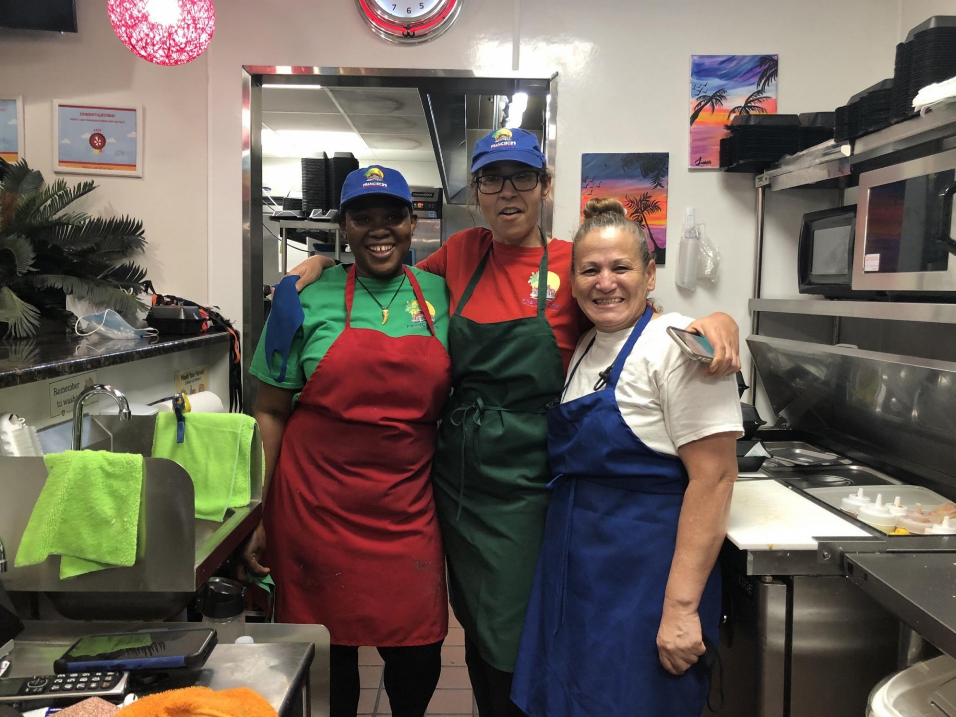 three women in aprons and hats in restaurant kitchen
