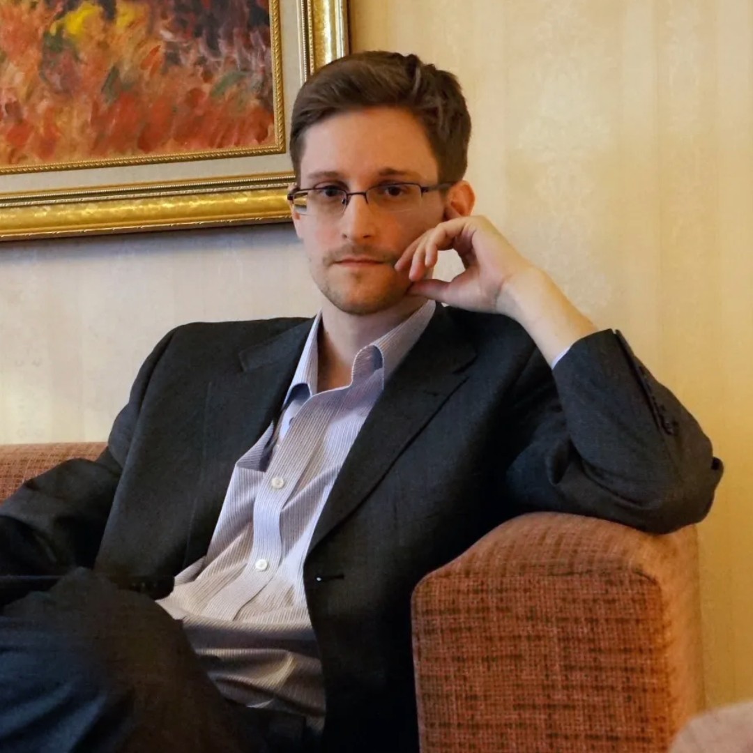 Janet Reitman, ’92 M.S., profiled Edward Snowden in Rolling Stone, tracing his path from IT contractor to whistleblower. Photo by Barton Gellman/The Washington Post/Getty. A man sits in a chair, his arm propped up and hand resting on his face.