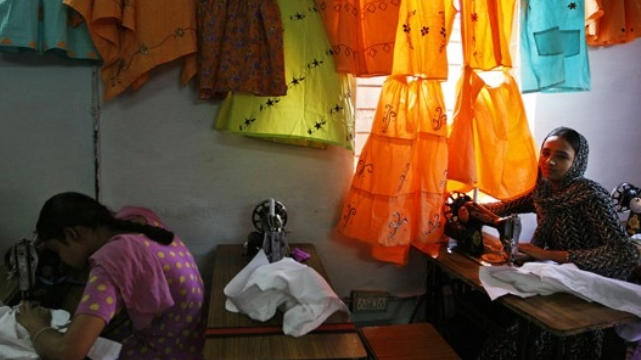 Elisabeth Bumiller, ’79 M.S., gave voice to the experiences of South Asian and Japanese women in her work. Photo by Ruth Fremson/The New York Times Women sewing in a dark room.