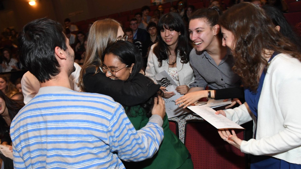 Group of students celebrating in an auditorium. 