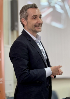 Juan Manuel Benítez, at Liceo Statale Felice Bisazza in Messina, Sicily, speaking on language, journalism and freedom of expression. Man in a suit giving a presentation.