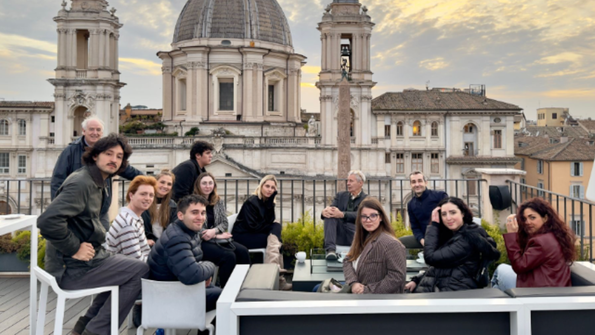 Professors Juan Manuel Benítez and Alexander Stille connect with future journalists during a recent meet and greet with accepted students in Rome, Group gathering with a cathedral in the background.