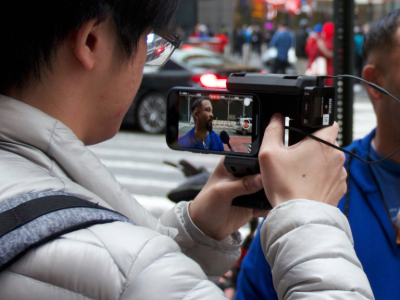 Man filmed through the lens of a smartphone.