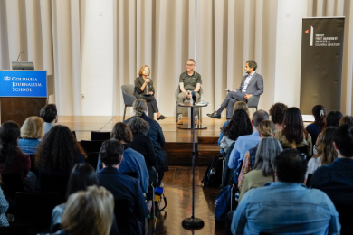 A three-person panel on a stage. 