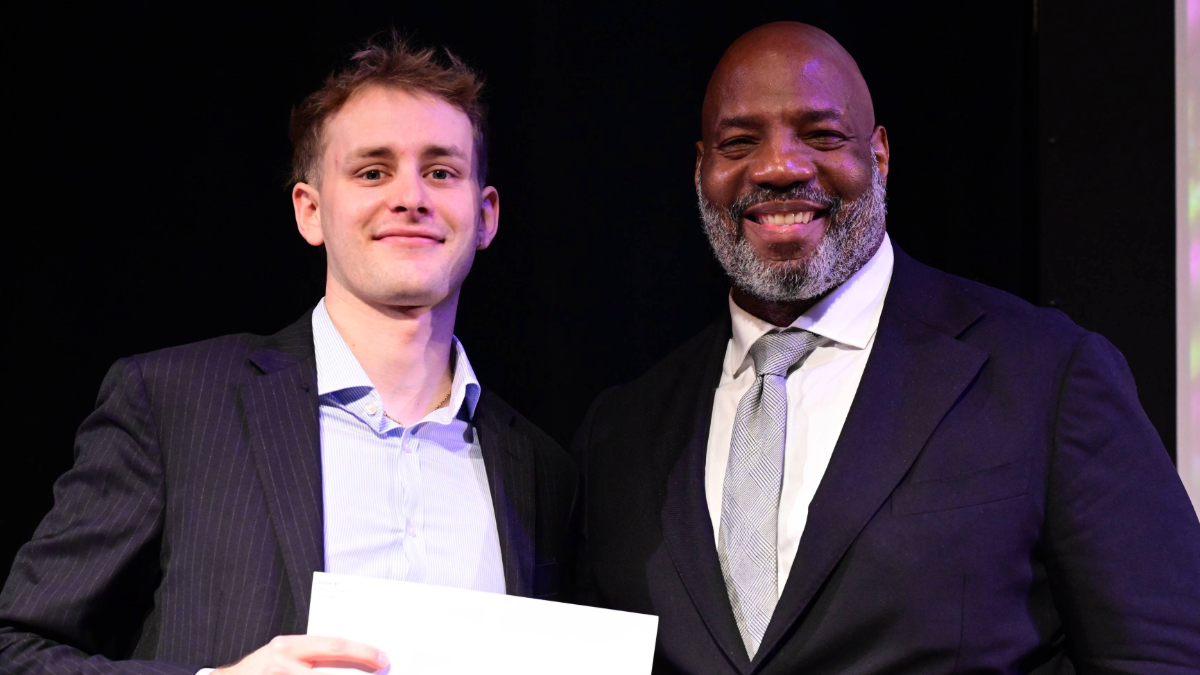 Johnny Sturgeon accepting his Pulitzer Traveling Fellowship from Dean Jelani Cobb. Two men pose for a photo.