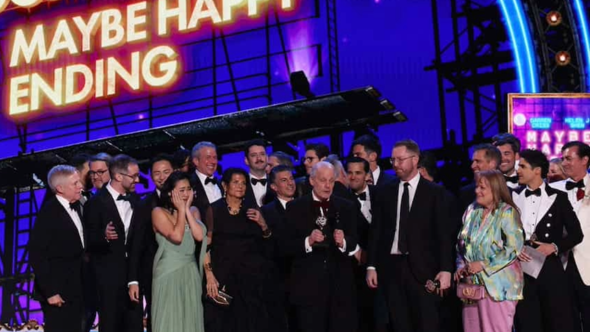 Group on stage accepts an award. 