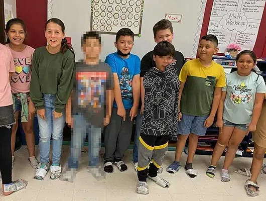 Elsa Avila’s students pose for a picture in their newspaper shoes moments before the shooter entered their school. Children’s faces are shown with parental consent. Credit: Courtesy of Elsa Avila, pixelated by ProPublica, The Texas Tribune, and FRONTLINE