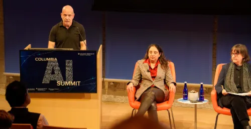 Man stands at a podium that reads "Columbia AI Summit."