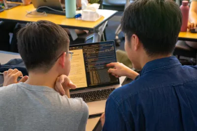 Students collaborating and reviewing projects in a data journalism class.