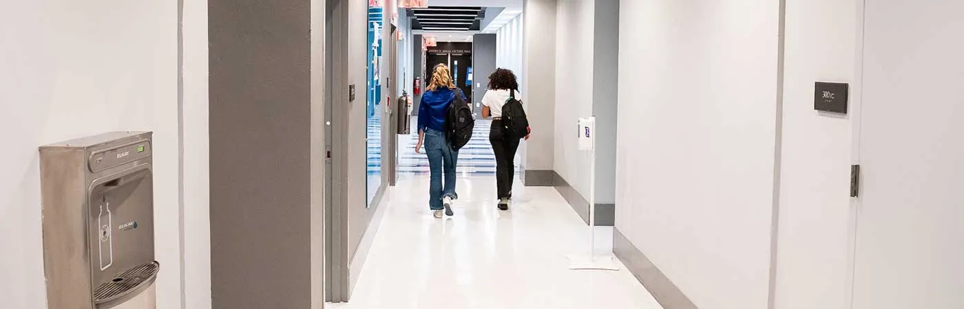 Two students walking down a hallway in Pulitzer Hall