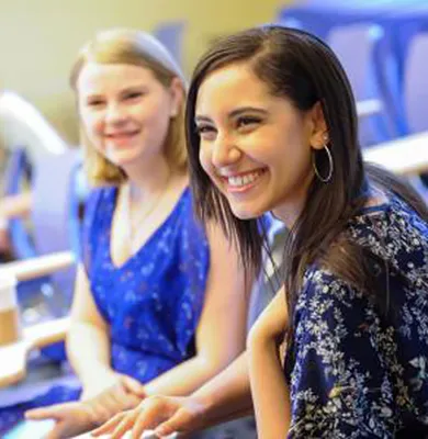 Two women smiling at someone off camera to the left