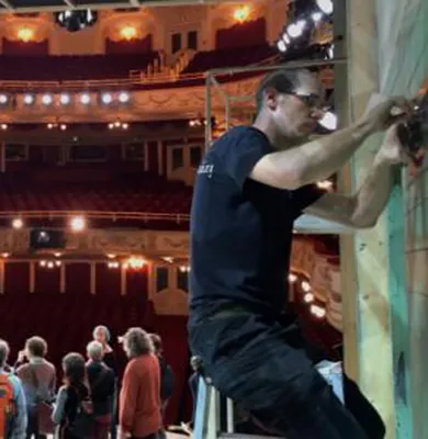 A man working on building a stage set, Master of Arts in Journalism