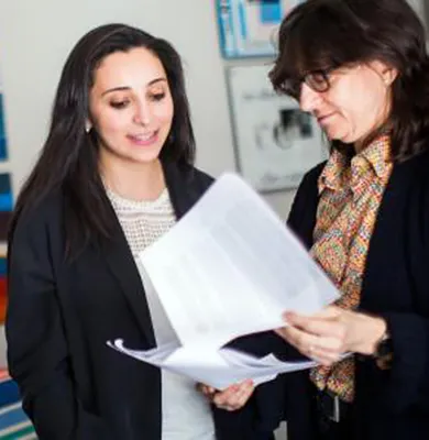  Two people engaged in a discussion while holding papers
