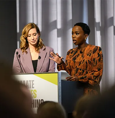Two women speaking behind a podium. 