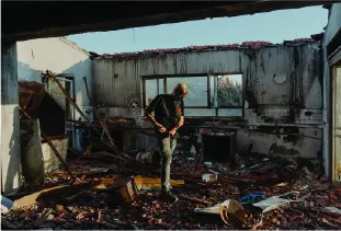 Gal Cohen, the secretary-general of Be’eri, in a destroyed home in Kibbutz Be’eri.Photographs by Ofir Berman for The New Yorker
