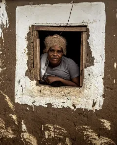 A woman standing in a window frame. 