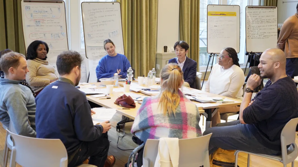 Sulzberger fellows sit around a table during a discussion. 