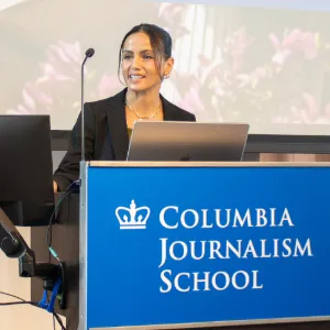 Hind Hassan speaking at a Columbia Journalism School podium. 