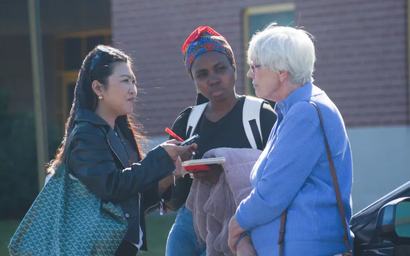 Two individuals interview someone. 