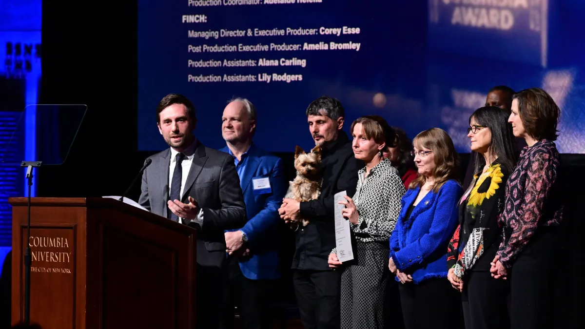 The nine-person team behind the silver baton-winning documentary "Porcelain War" addresses the ceremony crowd. Director Brendan Bellomo stands at the podium and speaks