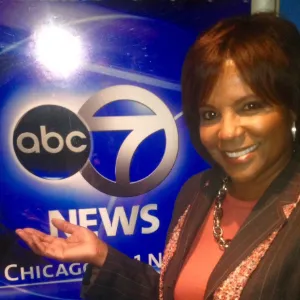 Diann Burns, '81 M.S., standing in front of the ABC 7 news logo