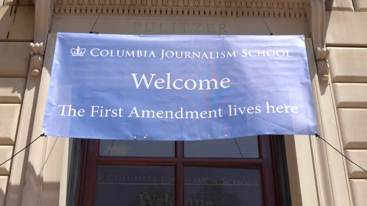 Banner outside Pulitzer Hall that reads "Columbia Journalism School. Welcome. The First Amendment Lives Here." 