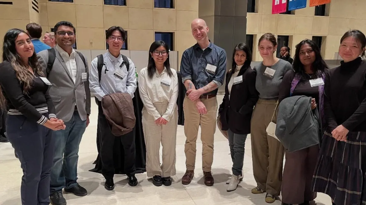 Group of people posed in a half circle. 