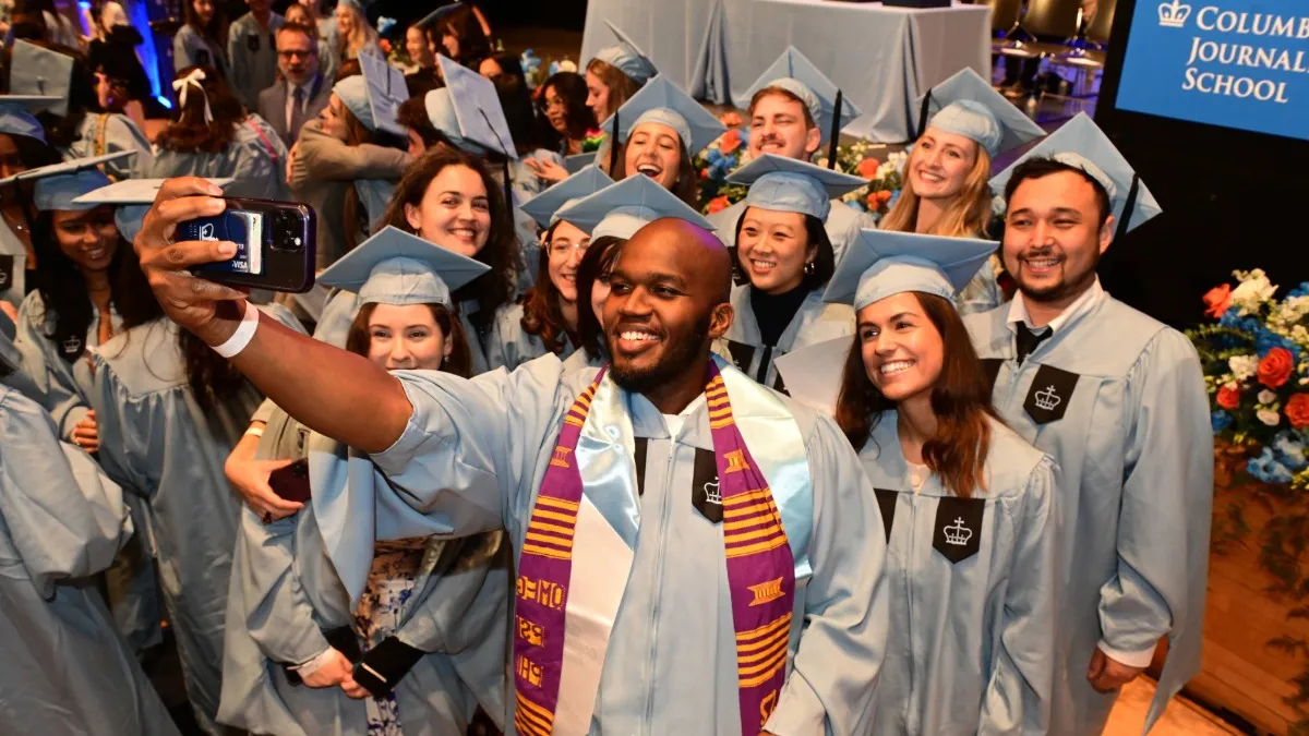 A group of graduates take a selfie together. 