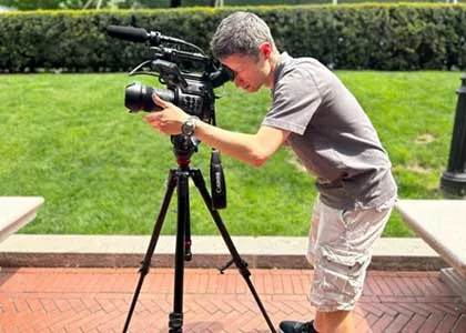 Student with video camera and tripod