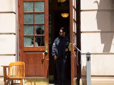 Photo of an officer in the doorway of Hamiltom Hall after the student occupation. 