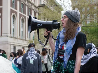 Students protesting on the lawn with a megaphone.