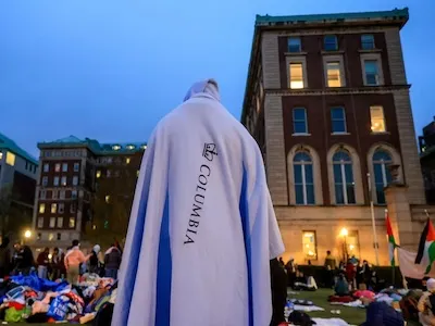 Photo of student during protest wearing a Columbia banner. 