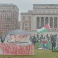 Tents with signs reading "Liberated Zone" and "Gaza Solidarity Encampment" are pictured on Columbia's south lawn, in front of Low Library.  