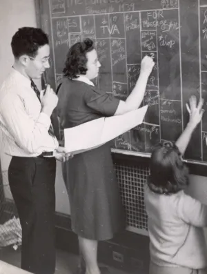 Students at Columbia Journalism School writing on a chalkboard in the early-mid 1900s. 