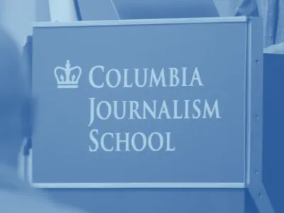 Columbia Journalism School logo on a podium. 