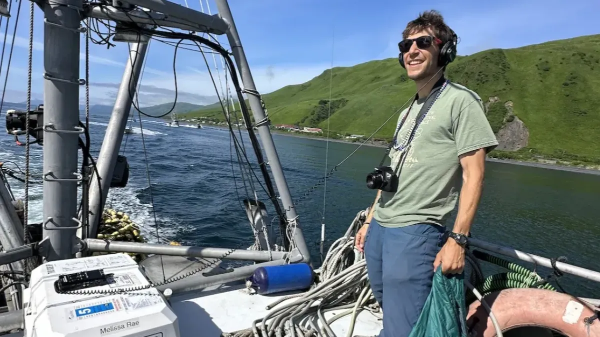 Nathaniel Herz stands aboard a salmon seiner while on a reporting trip to the Kodiak Island village of Old Harbor. Credit: Courtney Carothers.