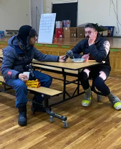 Nathaniel Herz interviews Iditarod musher Pete Kaiser at a checkpoint of the K300 dog sled race in Aniak, Alaska. Credit: Max Graham. 