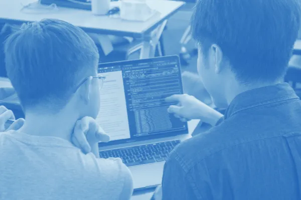 Two students using a laptop. 
