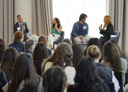 Panel discussion with four speakers and an audience.