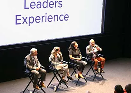 Dean Duy Linh Tu, '99 M.S., moderating a discussion on sustainability during the opening keynote for Columbia Alumni Leaders Experience. A screen located behind the panelists reads "Leaders Experience"     